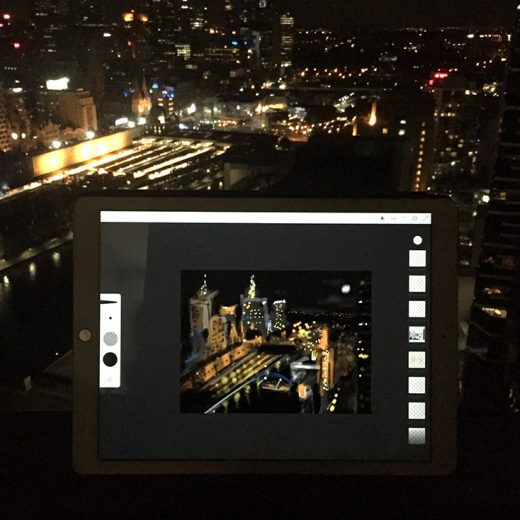 Ipad with view and digital illustration of Melbourne city at night by Alison Davies